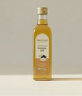 Bottle of Adavi Farms Sesame Oil on a beige background
